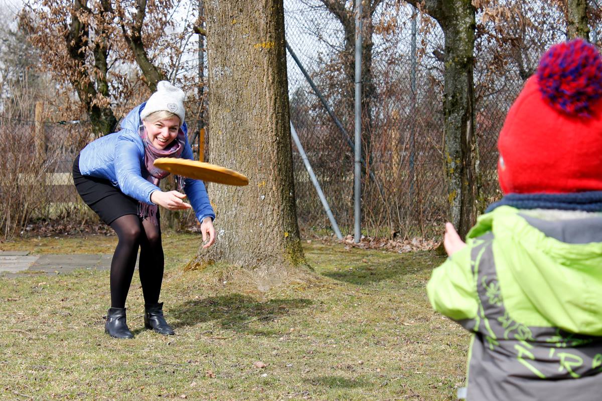 Katharina Schulze spielt Frisbee im Garten der KiTa Wawuschel